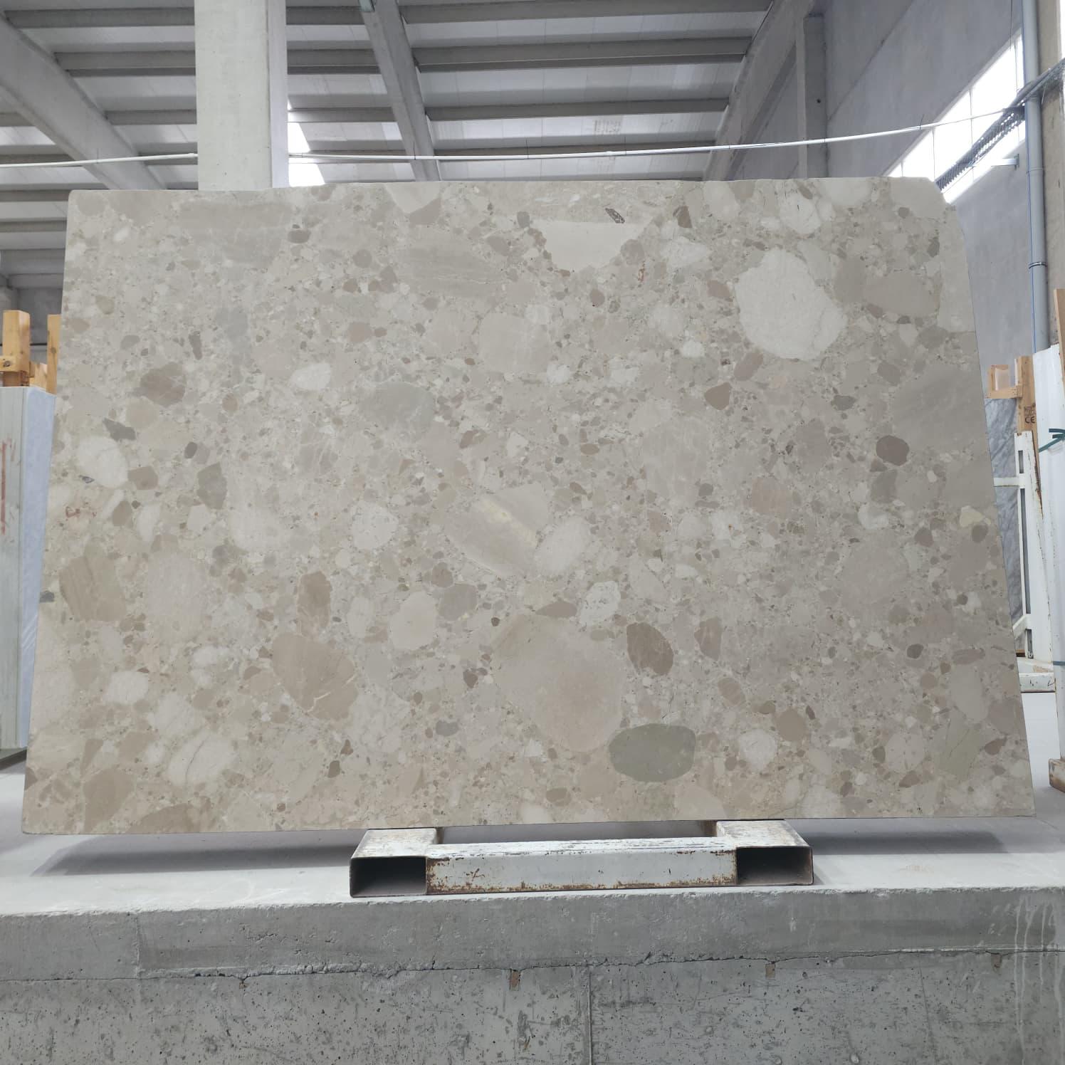 Ceppo marble slab with cream field and dense aggregate of warm beige and grey pebble-like inclusions