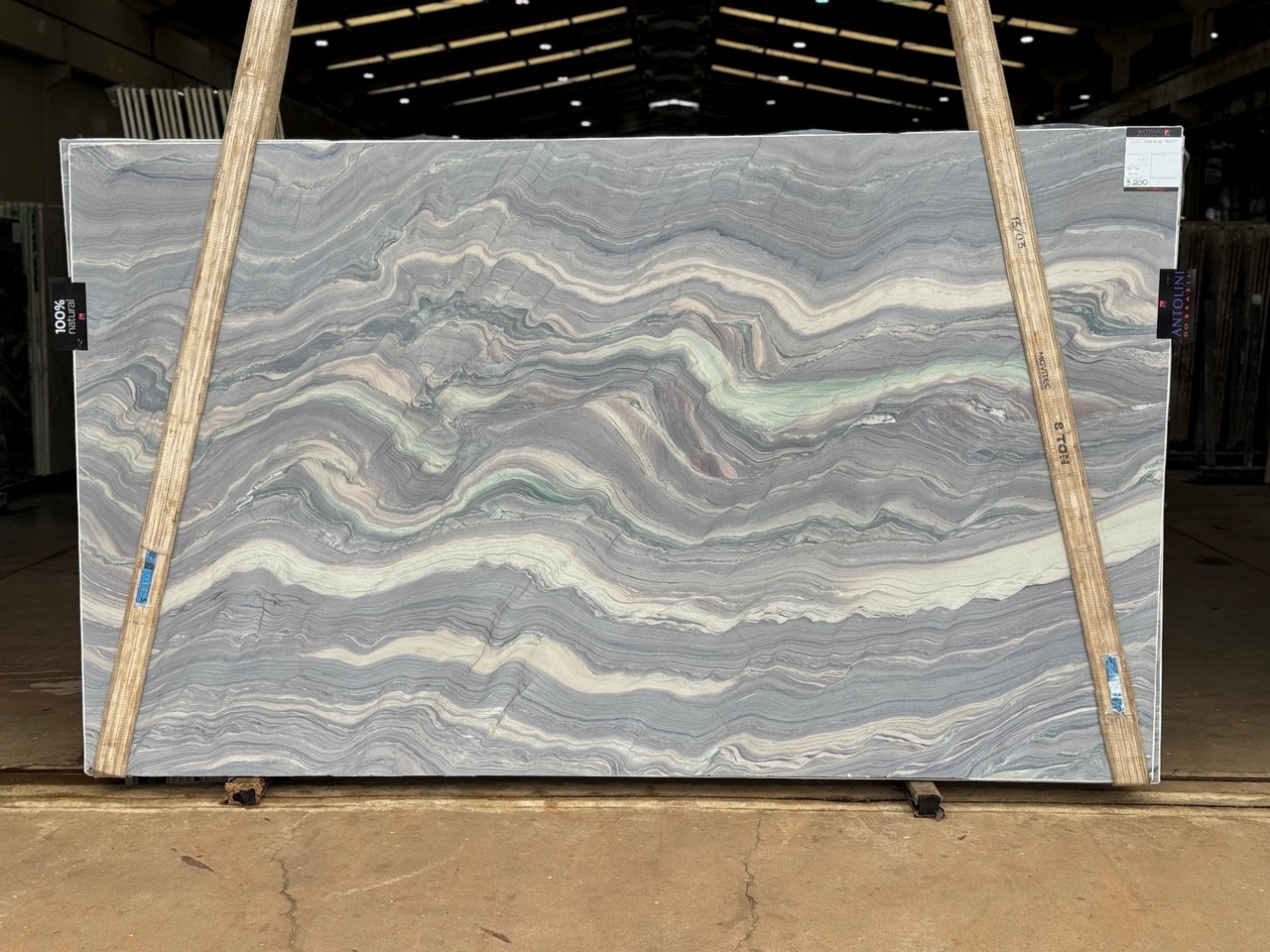 Antolini Explosion Blue Select quartzite slab with wavy blue, cream, and pink banded movement
