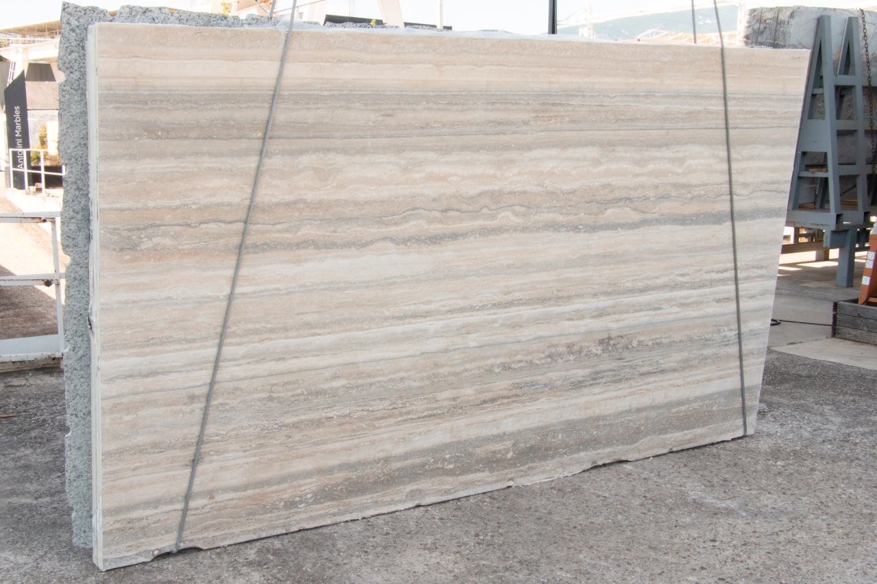 Antolini travertine slab, vein cut, with silvery-grey linear banding across a warm ivory field