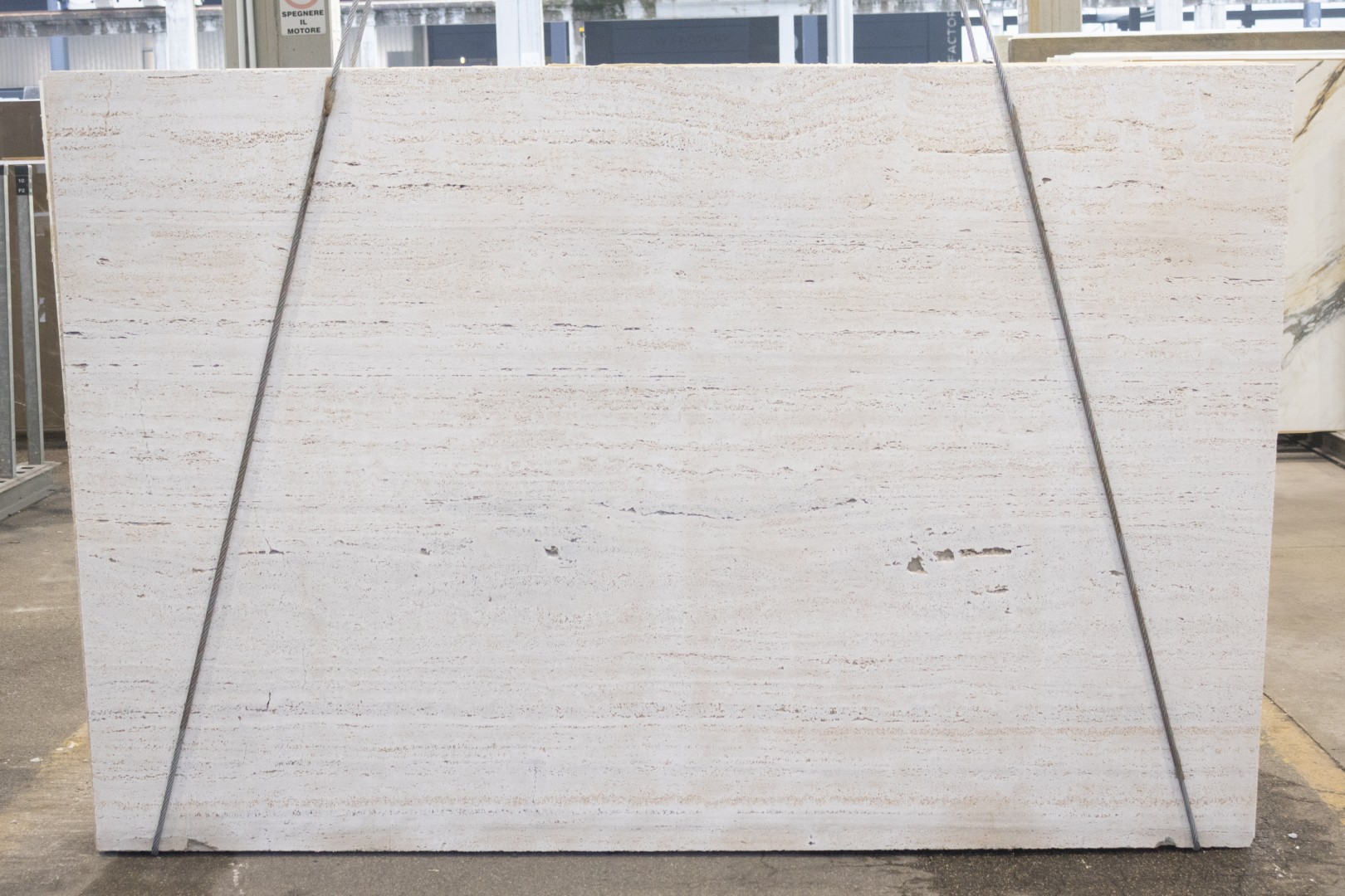 Antolini travertine slab, vein cut, in clean ivory with quiet horizontal linework