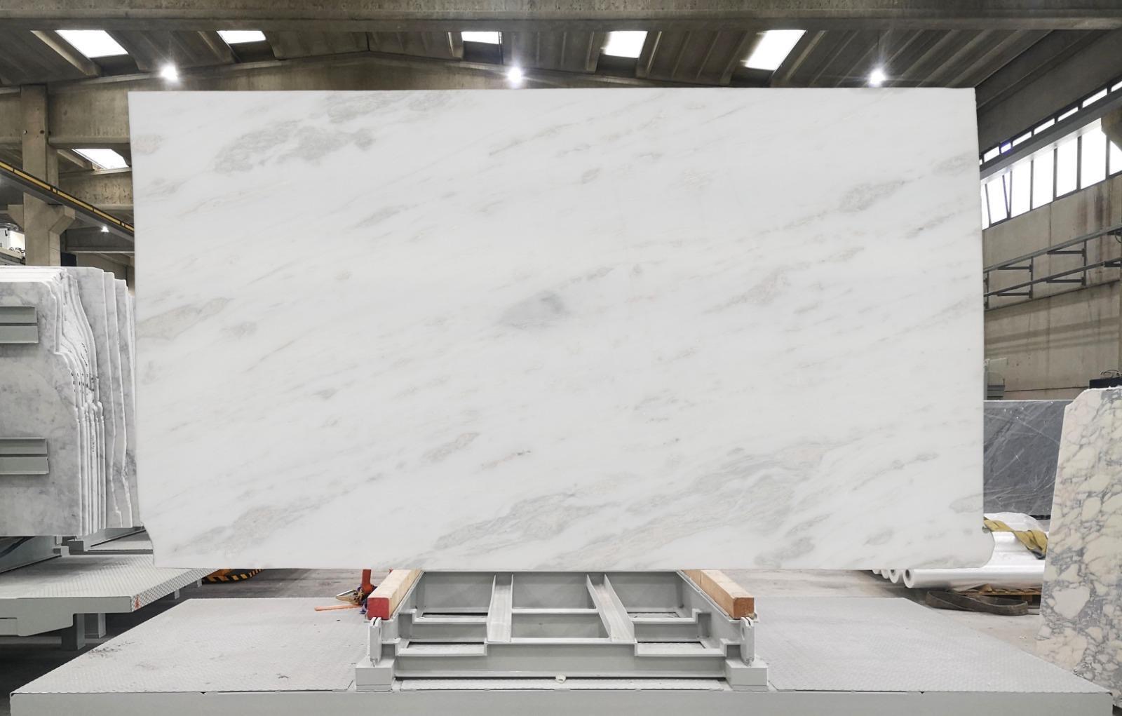 White Italian marble slab with bright white field and quiet silver-grey veining, photographed at the factory