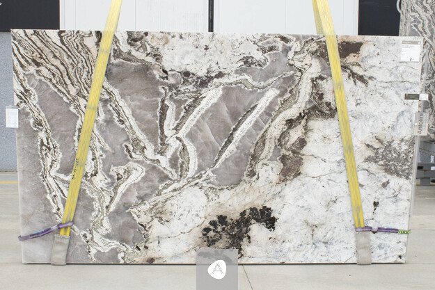 Antolini Patagonia Bianco quartzite slab with cream-white field and dramatic grey-brown veining, polished