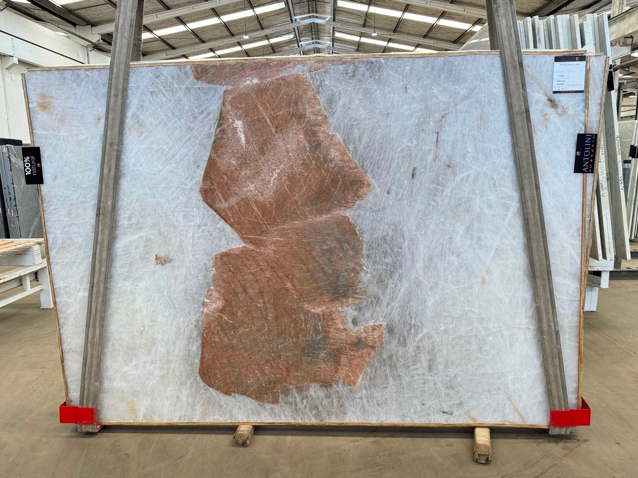 Antolini Patagonia Glace quartzite slab with translucent white field and a single rust-orange mineral inclusion