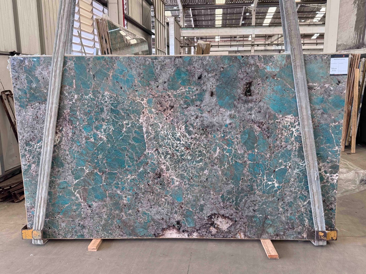 Antolini Amazonite Extra quartzite slab with turquoise mineral pockets and grey-pink veining, photographed at the factory