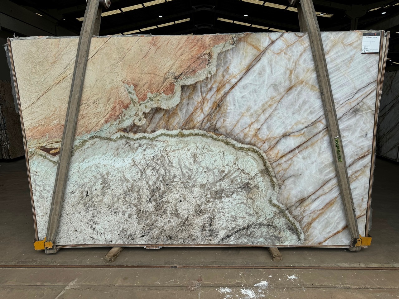 Antolini Patagonia Vitrum quartzite slab with translucent cream field and rust, gold, and green mineral pockets