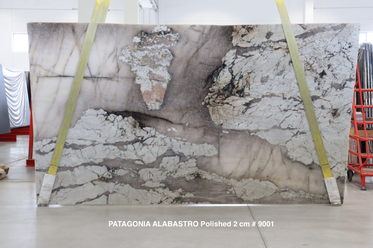 Antolini Patagonia Alabastro quartzite slab with translucent pink-grey field and dramatic white cloud formations, polished