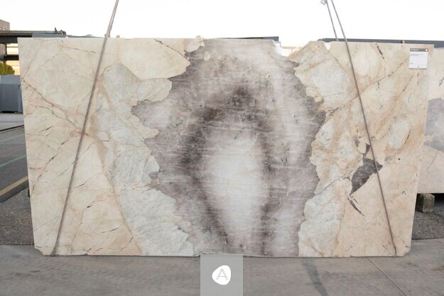 Antolini quartzite slab with translucent white field and a single charcoal mineral inclusion at center